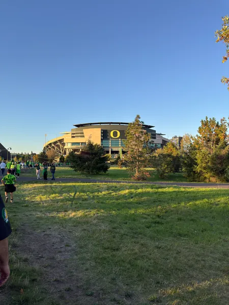 Autzen Stadium appears beyond an open stretch of grass.