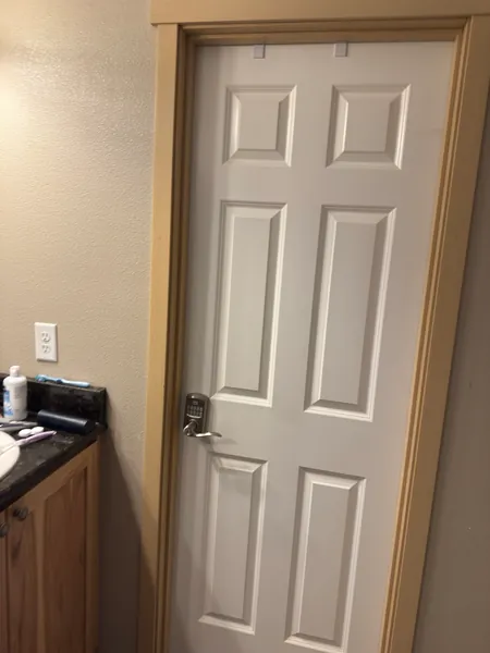 A closed white door receives an unexplained portrait.