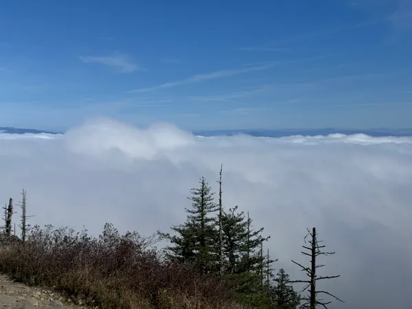 Blue sky and a cloud bank beyond the ridge.