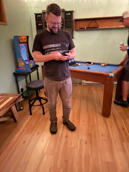 A guest checks a phone while standing by the table.