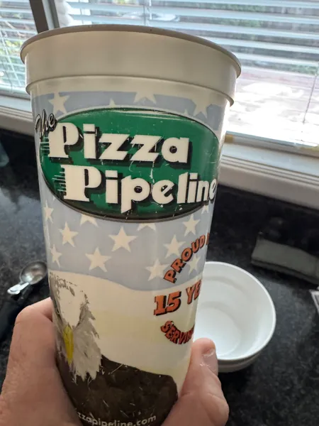 A Pizza Pipeline cup at the table.