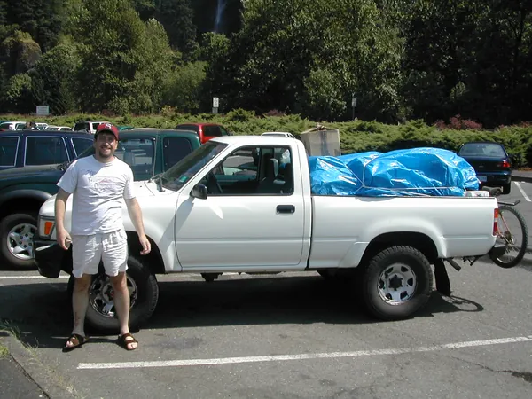 A traveler opens a pickup door in a parking lot.