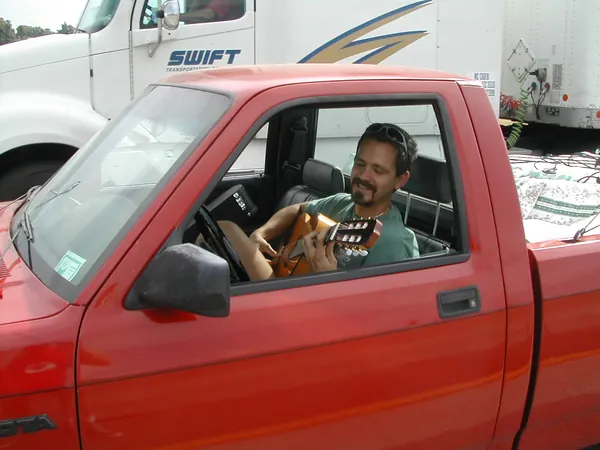 A closer view of the driver in the red pickup.
