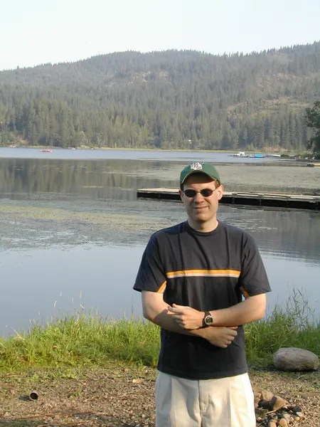 A traveler poses beside the lake.