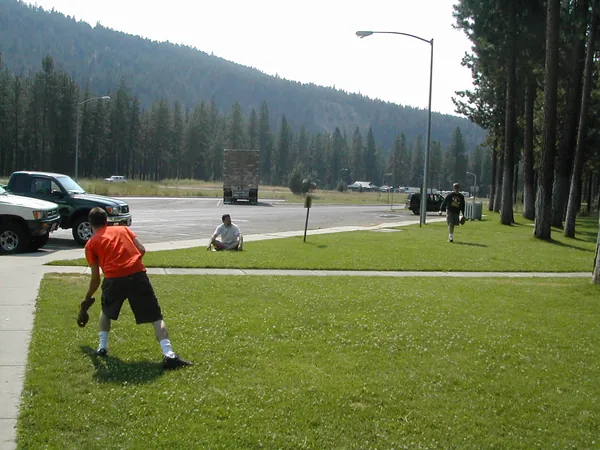 A traveler adjusts gear on the grass.