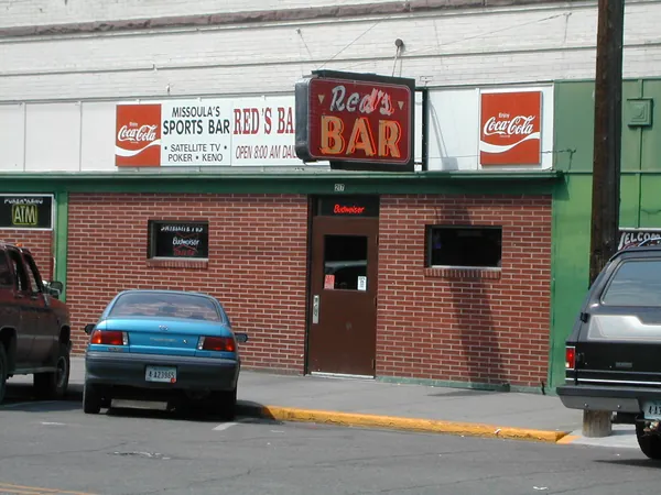 A small-town bar and parked car.