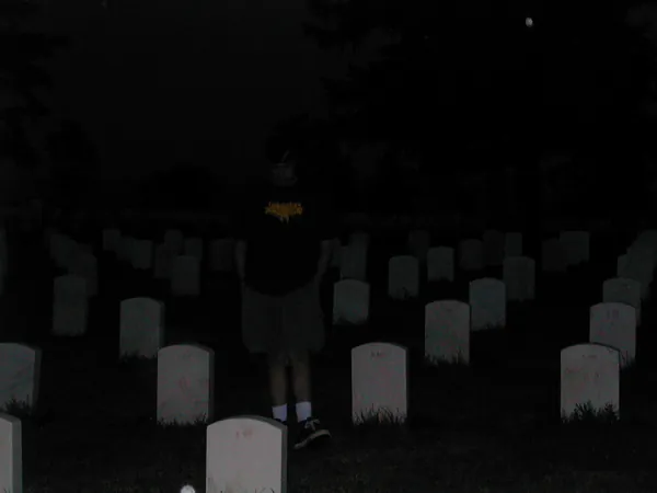 Travelers walk among the markers after dark.
