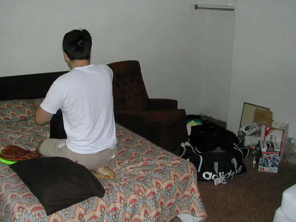 A traveler sits on a motel-room bed.
