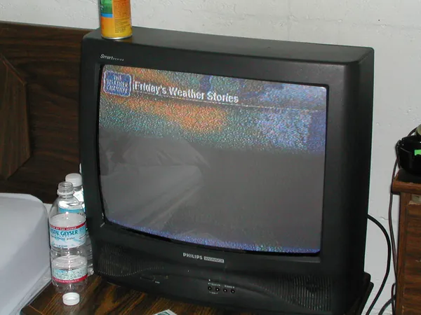 A television glows in the motel room.