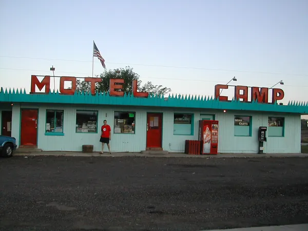 The low motel building beneath a clear morning sky.