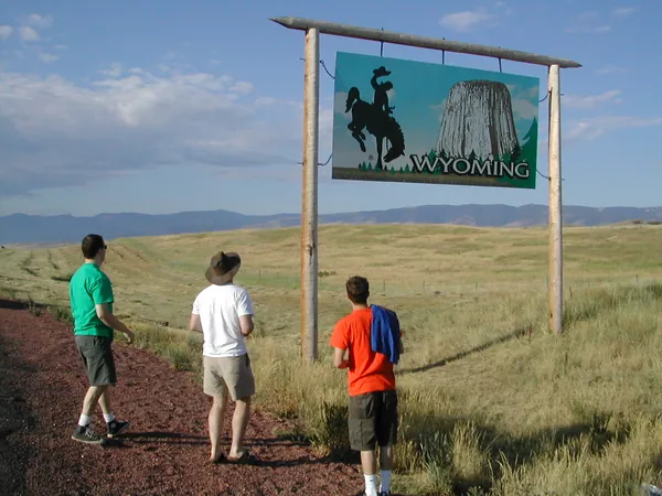 Travelers walk toward the Wyoming sign.