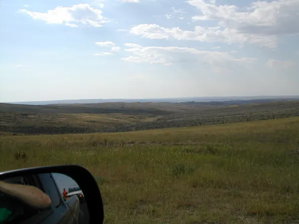 Open plains viewed from the vehicle.