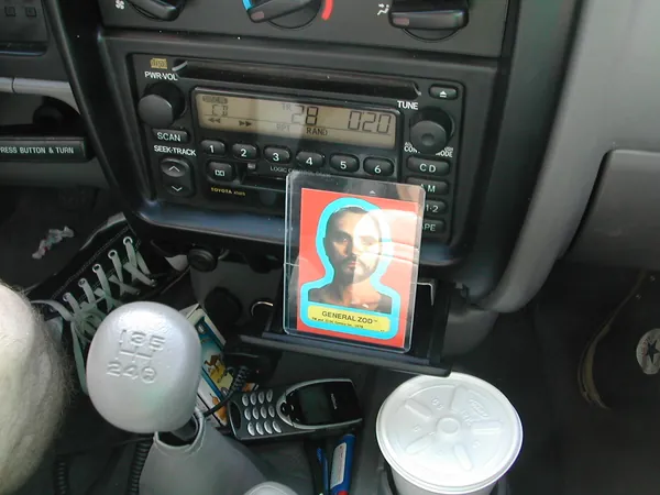 A small portrait card propped against the dashboard.