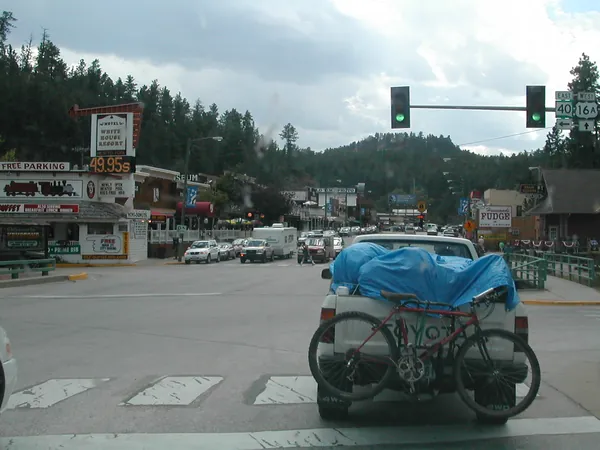 The tarp-covered pickup traveling through an intersection.