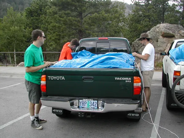 Travelers secure the tarp on the pickup.