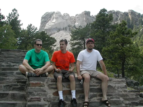 Three travelers sit together at the overlook.