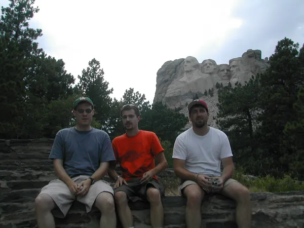 Three travelers pose with the granite landscape behind them.