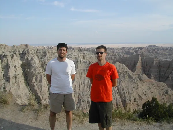Two travelers pose at a Badlands overlook.