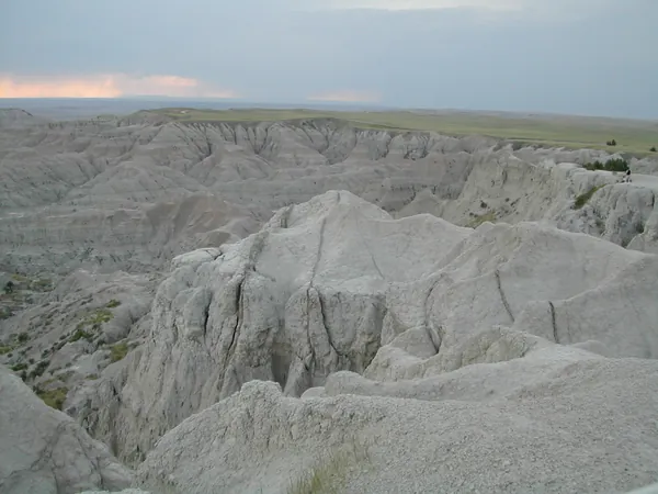 Pale Badlands formations under a hazy sky.