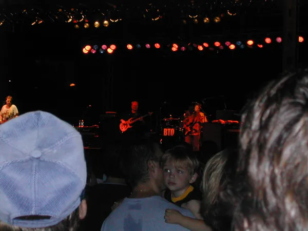 Stage lights above a nighttime crowd.