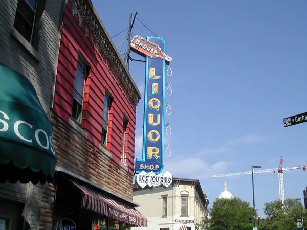 A vertical theater sign on a sunny downtown street.