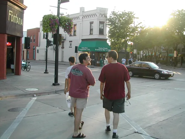 Travelers walk along a downtown street.