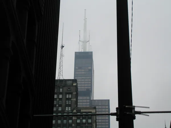 A tall Chicago skyscraper framed between buildings.