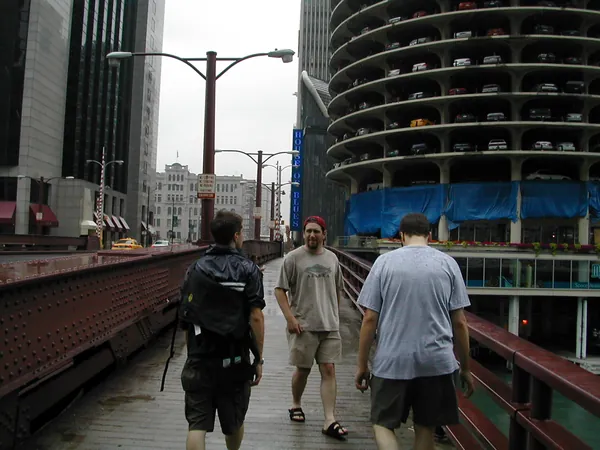 Travelers cross a bridge above the river.