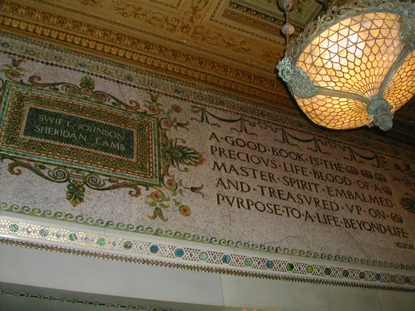 An ornate interior inscription and hanging lamp.