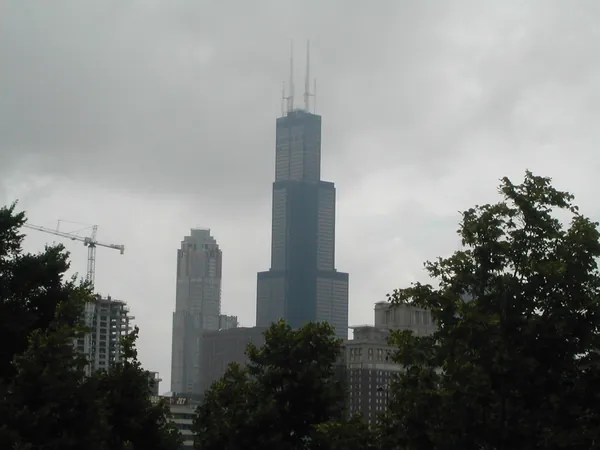 A dark tower partly hidden by trees.