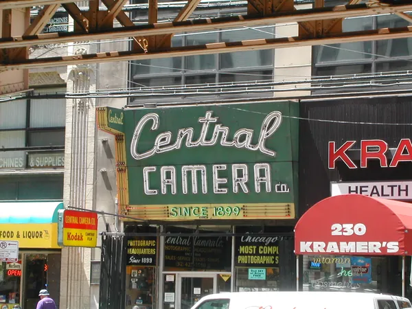 A vintage camera-store sign above the street.