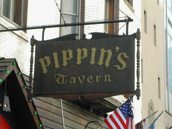 A tavern sign hanging above the sidewalk.