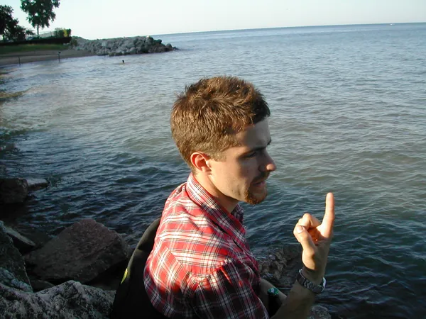 Another traveler poses beside the lake.