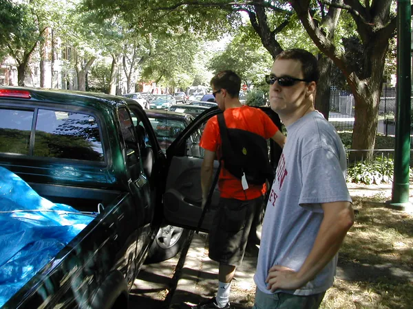 Two travelers stand beside the loaded pickup.
