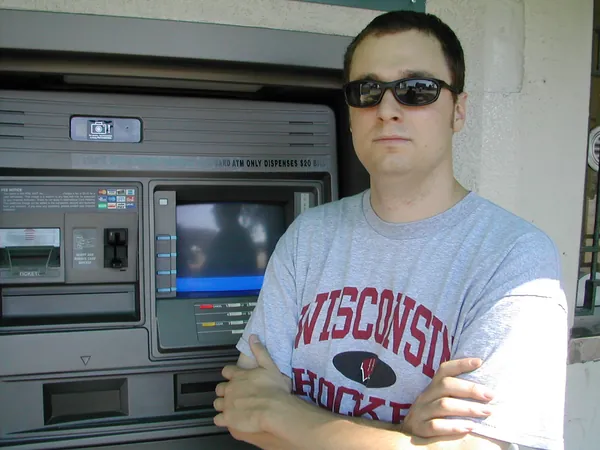 A traveler pauses beside an automated teller machine.