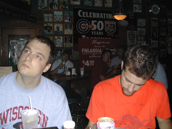 Two travelers sit together inside a restaurant.