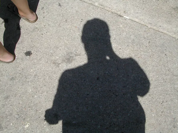 The photographer's shadow on the pavement.