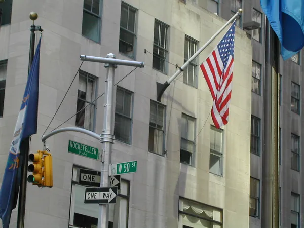 Street signs and American flags near Rockefeller Center.