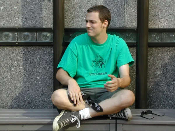 A traveler in a green shirt sits nearby.