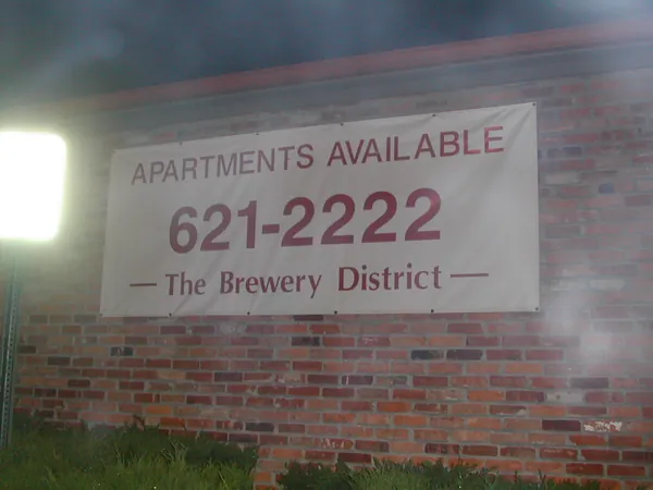 An apartment-rental sign painted on a brick wall.