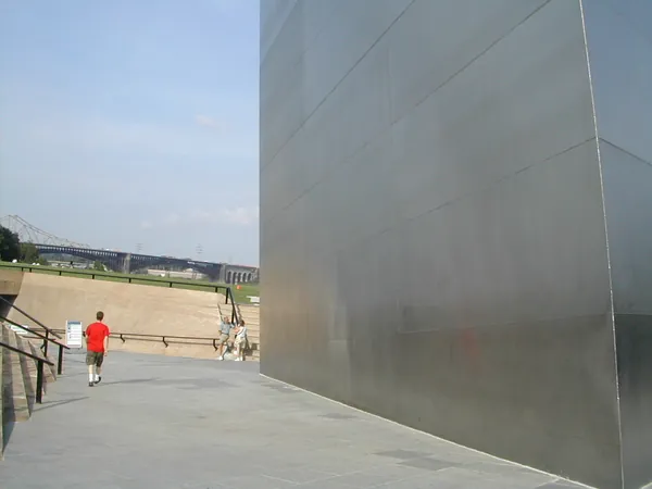 A traveler walks near the base of the arch.
