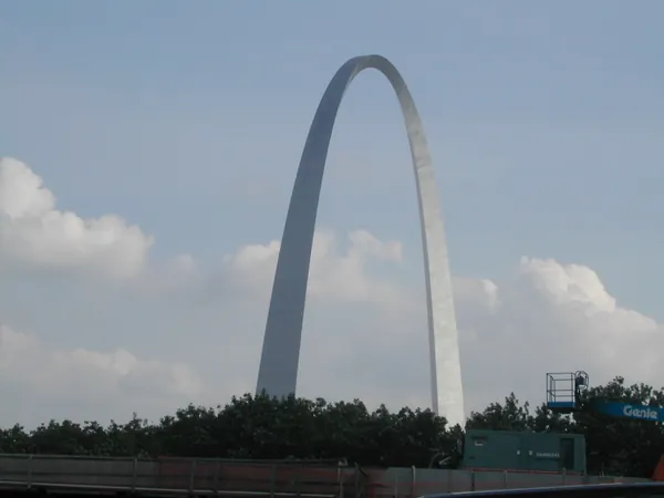 The Gateway Arch against a partly cloudy sky.