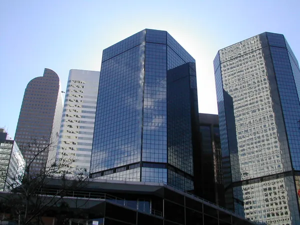 Reflective office towers against a blue sky.