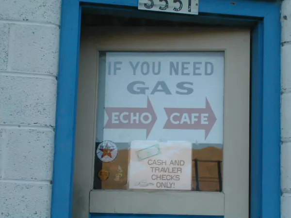 A small gas-station notice in a blue doorway.